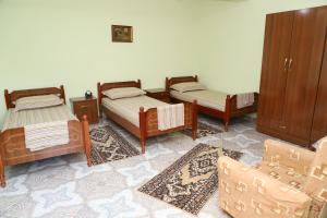 a group of four beds in a room at Villa Elena Gorice in Berat