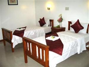 two beds in a hotel room with red and white sheets at Sunrise Resort in Mui Ne