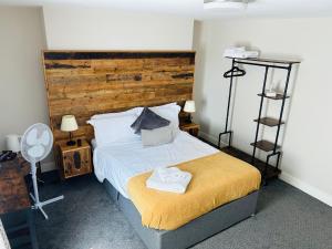 a bedroom with a bed with a wooden headboard at The Brookmill in London