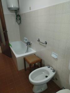 a bathroom with a toilet and a bath tub at Piccolo appartamento in montagna in Serina