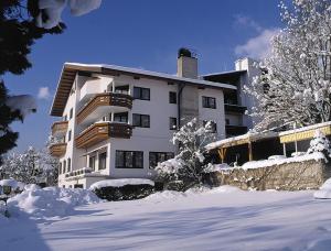 ein großes weißes Gebäude mit Schnee davor in der Unterkunft Appartement & Aparthotel Stern in Imst