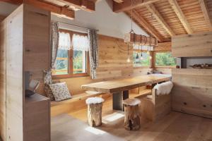 a dining room with a wooden table and some windows at Masetto dei Mughi in Pieve Tesino