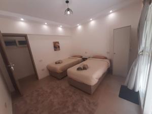a small room with two beds and a couch at New Cairo Zoé in Cairo