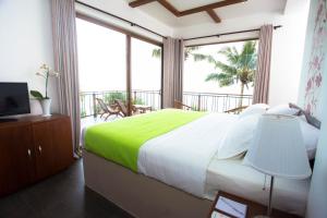 - une chambre avec un grand lit et un balcon dans l'établissement LakRaj Heritage, à Matara