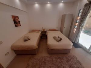 two twin beds in a room with a window at New Cairo Zoé in Cairo