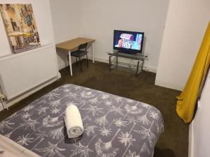 Pokój z łóżkiem, telewizorem i stołem w obiekcie Elegant Spacious Home w mieście Middlesbrough