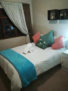 a bed with colorful pillows on top of it at Majestic View Lodge in Schoemansville