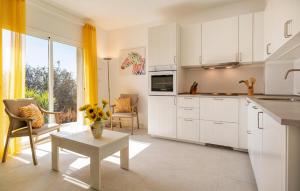 een keuken met witte kasten en een vaas met bloemen op een tafel bij 1 Bedroom Gorgeous Home In Arenas in Arenas