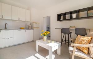 een keuken en een woonkamer met witte kasten en een tafel bij 1 Bedroom Gorgeous Home In Arenas in Arenas