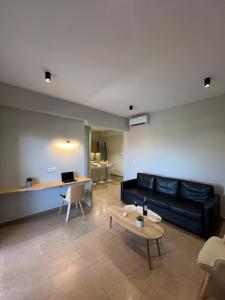 a living room with a black couch and a table at Modern Living Kefalonia in Lakíthra +12 photos