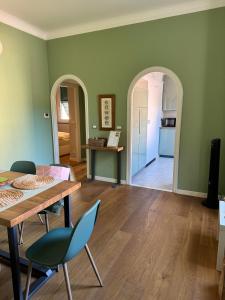 a living room with green walls and a table and chairs at Casa Nina Carignano in Genoa