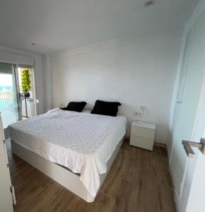 une chambre blanche avec un lit et une fenêtre dans l'établissement Las Vistas Faro de Cullera, Valencia, à Faro de Cullera