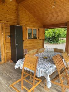 a wooden cabin with a table with chairs and a refrigerator at Chalet in Parois +4 photos