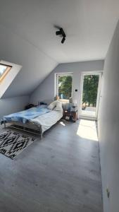 a bedroom with a bed in a room with windows at Wspaniały cały 5 sypialniowy dom in Leleszki