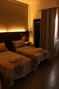 HanimaadhooSamaik Orange的一间有两张床和一扇窗户的酒店房间