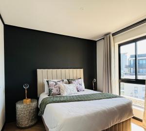 a bedroom with a large bed with a black wall at BGS Luxury Accommodation-One bed-Cape Town in Cape Town