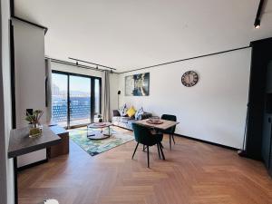 a living room with a table and chairs and a clock on the wall at BGS Luxury Accommodation-One bed-Cape Town in Cape Town