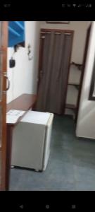 a small white refrigerator in a room with a door at solar das margaridas in Paraty +27 photos