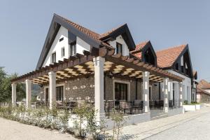 a house with a wooden roof with tables and chairs at Bistrička Čaršija in Bijelo Polje