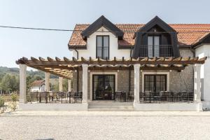 a house with a pergola with tables and chairs at Bistrička Čaršija in Bijelo Polje +26 photos