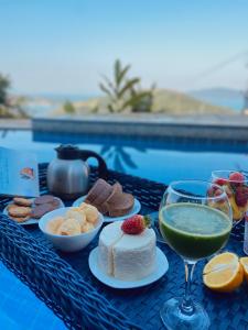 a table with desserts and a drink and wine glasses at Casa em Paraty, piscina com vista para o mar in Paraty