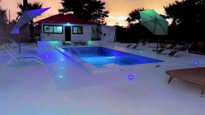 a swimming pool with blue lighting and umbrellas at La Fandenoise Lodge in Thiès