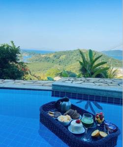 a tray of food sitting on top of a swimming pool at Casa em Paraty, piscina com vista para o mar in Paraty