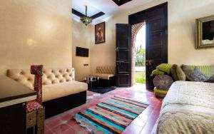a living room with a bed and a couch and a door at palais ghaiat in Had Abdallah Rhiat +11 photos