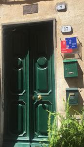 zielone drzwi do budynku ze znakami w obiekcie Case Rossa e Blu w mieście Villanova dʼAlbenga