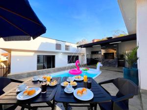 ein Tisch mit Tellern voller Essen und ein Swimmingpool in der Unterkunft Casa Temporada Rio Quente (Em frente ao Hot Park) in Rio Quente