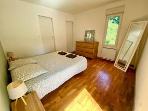a bedroom with a bed and a dresser and a mirror at Petit Launay - proche Rennes in Vezin-le-Coquet