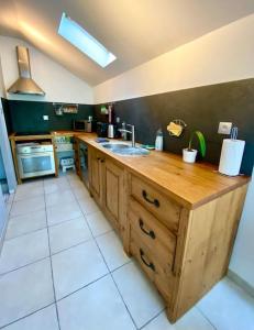 a kitchen with a wooden counter and a sink at Petit Launay - proche Rennes in Vezin-le-Coquet
