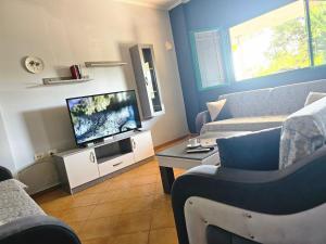 a living room with a couch and a tv at Kuqa Rent House in Ksamil