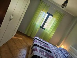 a bedroom with a bed and a window at Kuqa Rent House in Ksamil