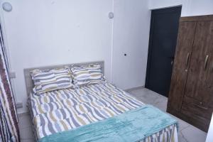 um quarto com uma cama e um armário de madeira em Cadet's Studio em Mahébourg