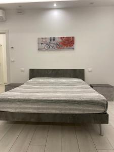 a large bed in a bedroom with a painting on the wall at RoomsCarli in Comacchio