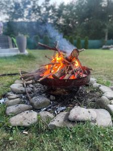 a fire pit on the grass with rocks at Pustelnika Chatka nad Brennicą in Brenna