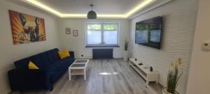 a living room with a blue couch and a table at Baltivia ADULTS ONLY in Świnoujście