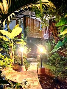 a garden with two candles in front of a house at Montelungo Cabañas Glamping in Chimbe