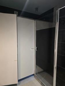 ジェロンカにあるHostel w Zielonceの白いキャビネット付きのクローゼット、ガラスドア