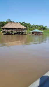 a building on the side of a river at Cabaña Flotante Kurupira in Leticia