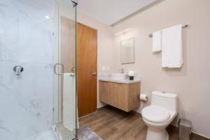 a bathroom with a toilet and a sink and a shower at Best view rooftop with heated jacuzzi in Cabo San Lucas +31 photos