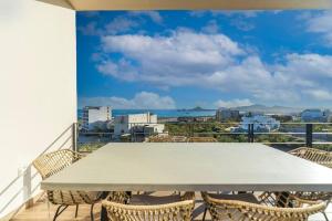 a table and chairs on a balcony with a view of the ocean at Best view rooftop with heated jacuzzi in Cabo San Lucas