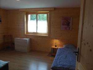 ein kleines Schlafzimmer mit einem Bett und einem Fenster in der Unterkunft Les Promenades en Montagne in Chateau-d'Oex