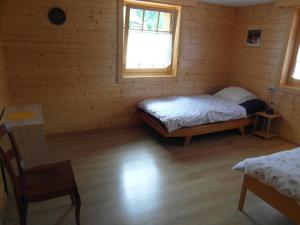 ein Schlafzimmer mit einem Bett und einem Stuhl in einem Zimmer in der Unterkunft Les Promenades en Montagne in Chateau-d'Oex + 7 Fotos