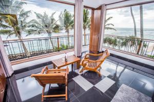 a balcony with a table and chairs and the ocean at LakRaj Heritage in Matara