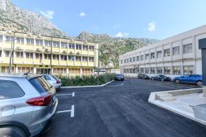 a parking lot with cars parked in front of a building at Modular Central Studio in Kotor