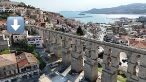 an old bridge in a city with an arrow on it at Under the Aqueduct boutique house in Kavála