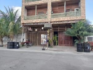 a building with a motorcycle parked in front of it at Quarto 01, com cama de casal, ar condicionado e TV in Coxipó da Ponte