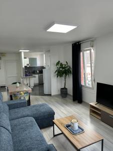 una sala de estar con un sofá y una mesa en Au Coin Champenois Epernay, en Épernay